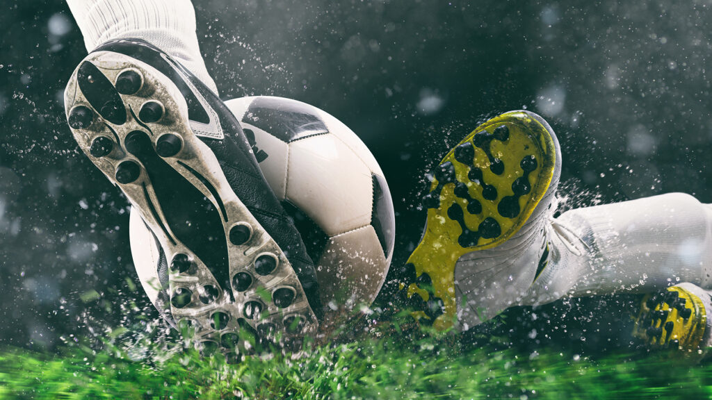 Soccer player kicks the ball vigorously at the stadium